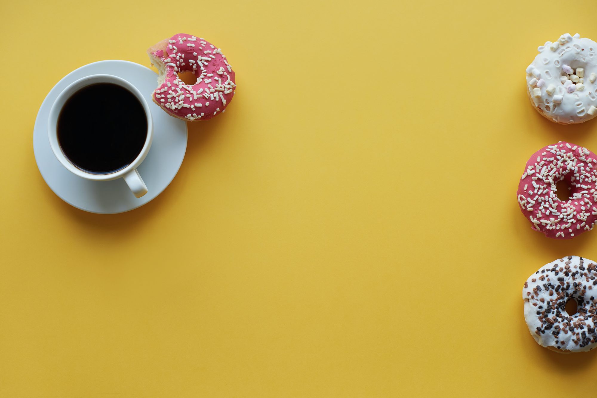 Picture of a coffee cup with several doughnuts